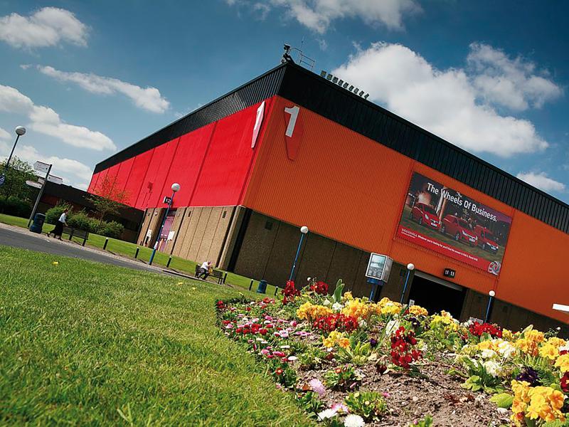 Red building viewed from its left angled with garden in front.