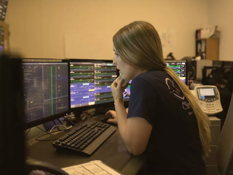Female paramedic sitting by the computer, making a call.
