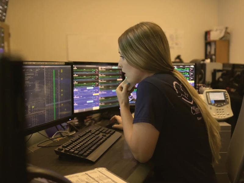 Female paramedic sitting by the computer, making a call.