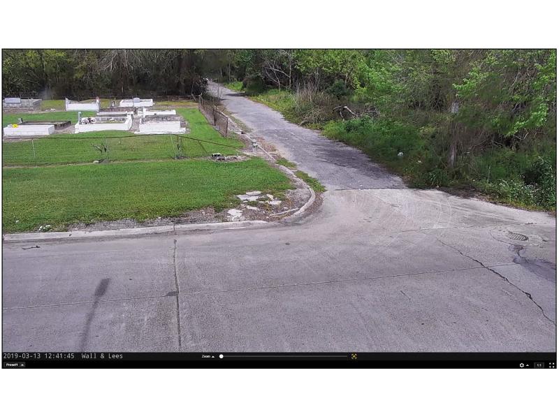 Screenshot of road turn, grass and small white buildings.