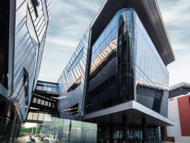 Glass building's exterior viewed from below.