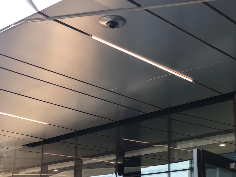 Axis camera on grey ceiling.