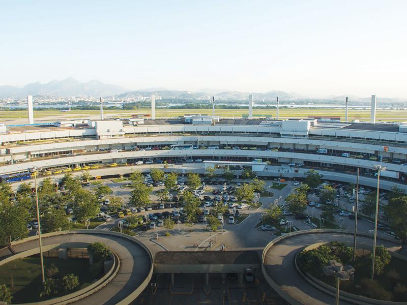 Circular parking garage viewed from outside with trees and roads in front.