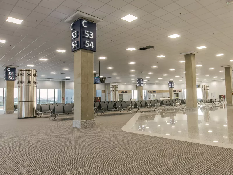 Gate waiting area, grey seats and poles.