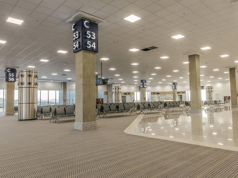 Gate waiting area, grey seats and poles.