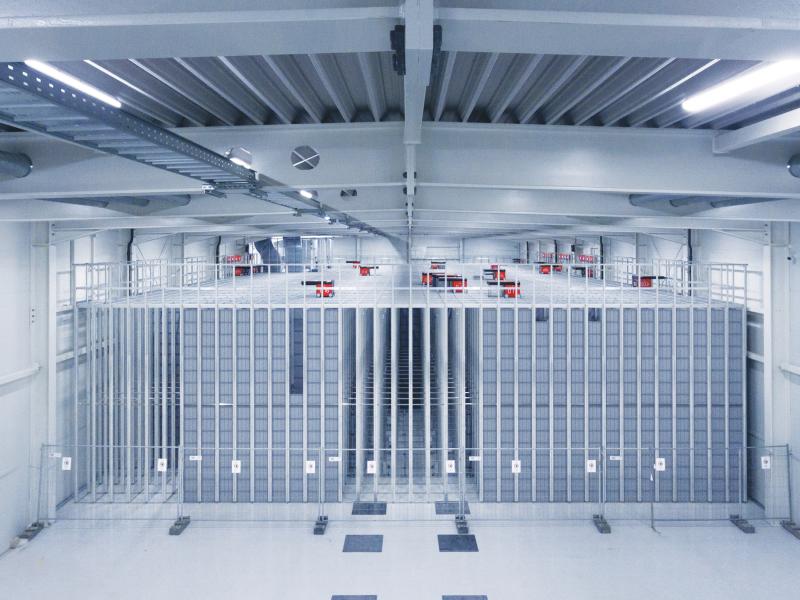 Grey room with large cubes behind bars.