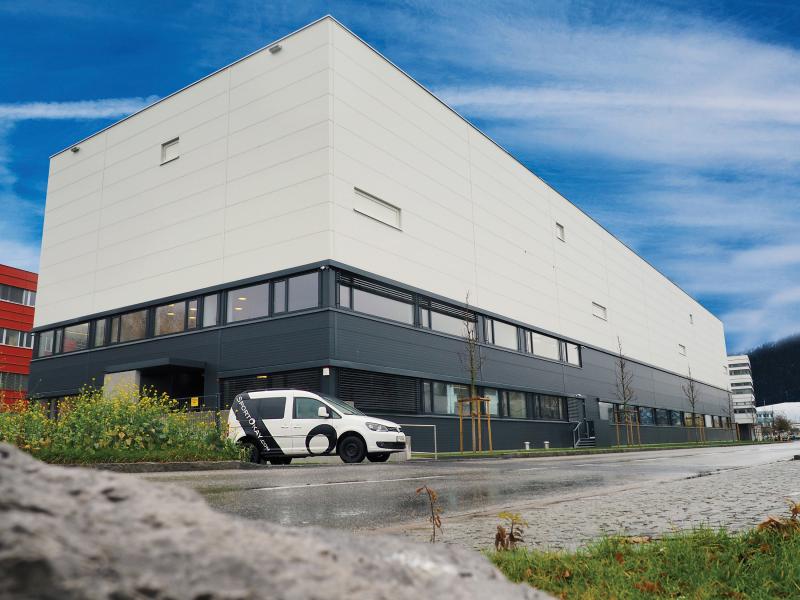 White and black building viewed from its right angle, one company car in front.