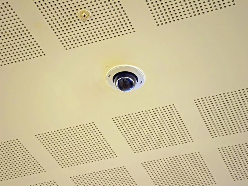 Axis camera in yellow ceiling viewed from below.