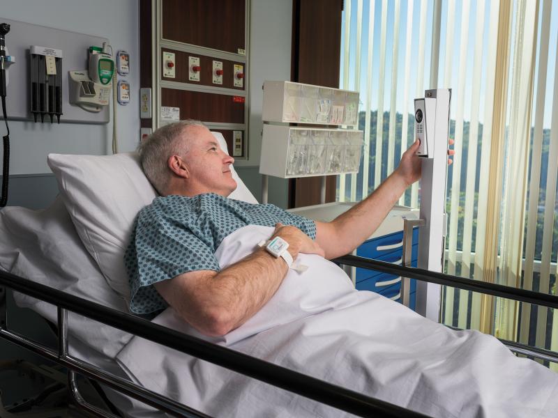 Patient laying in hospital bed use a virtual visitation service
