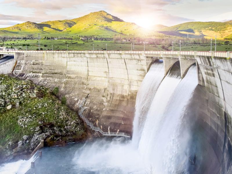 Dam waterfall in front of a open landscape 