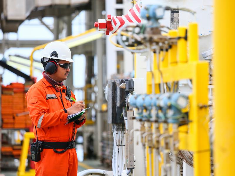 Man cheicking oil gas pipes