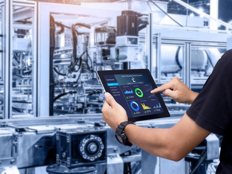 Man point at a tablet in a machine hall
