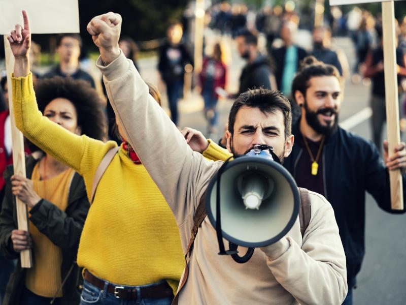 Upset crowd of protester with a megaphone in a demonstration