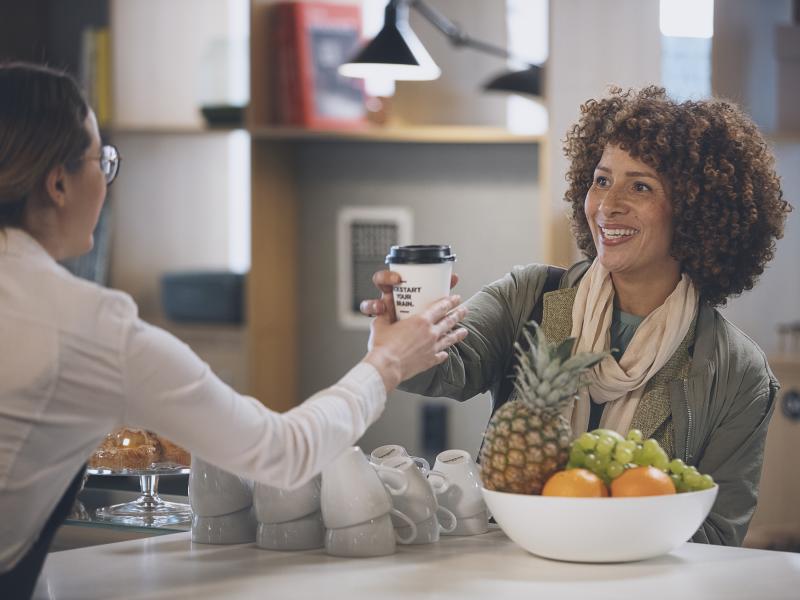 Woman is served take away coffee in a bank