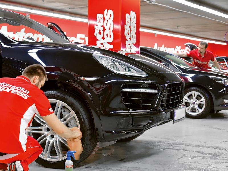 Automycka Express worker adjusting tire on a car