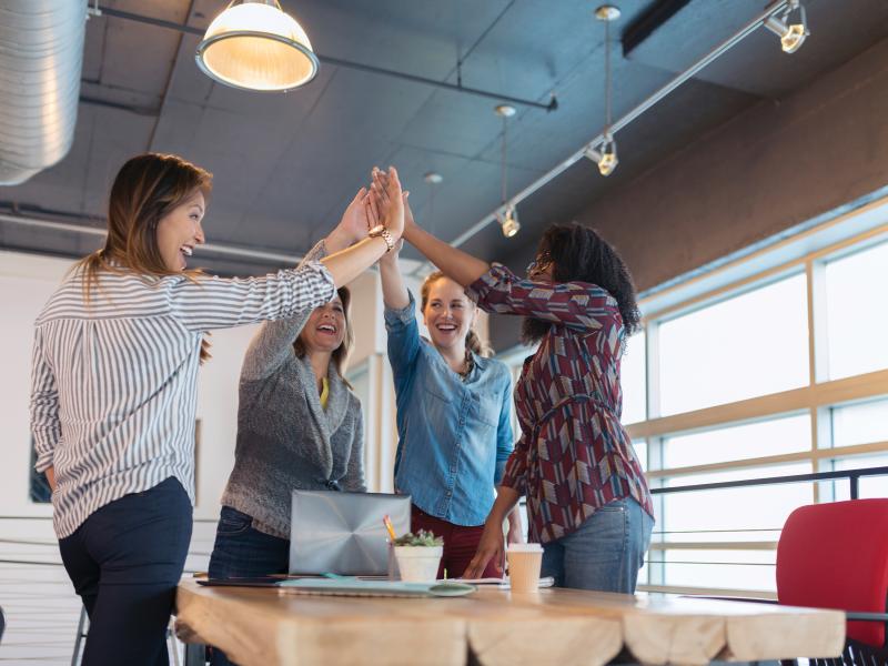 Group-women-high-five-laptop-meeting