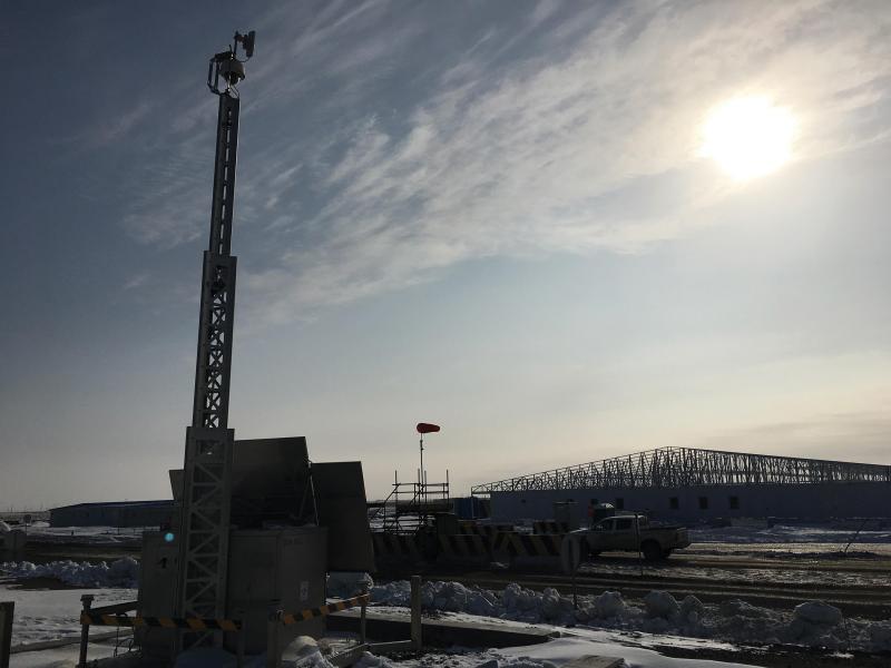 Evening view over oil field with security camera on pole