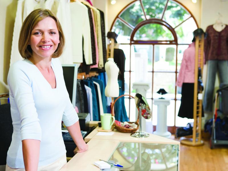 Female shop owner smiling in fashion store.