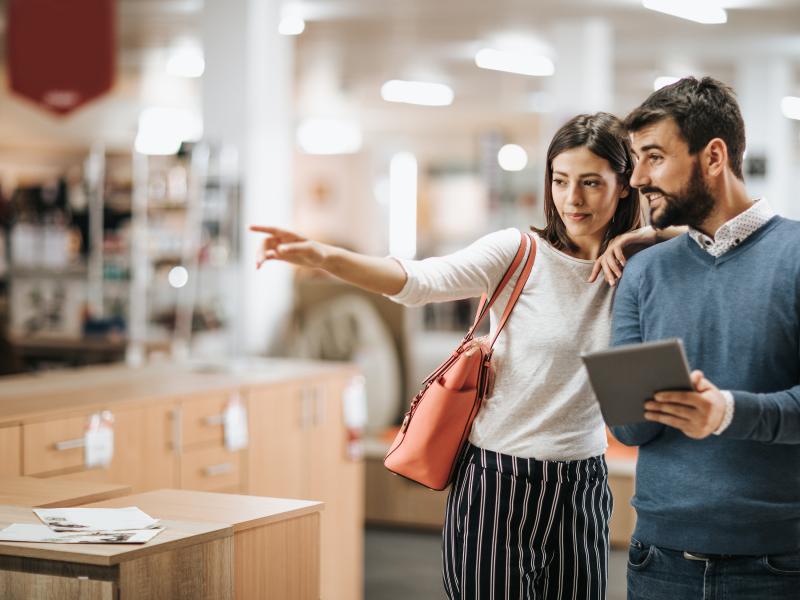 Woman and man shopping furniture, the man is holding a tablet