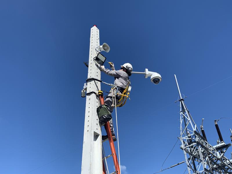 Man installing camera on pole