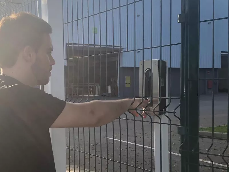 Man in front of fence with access control system