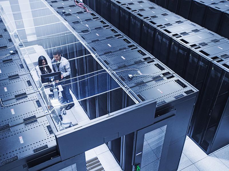 Man and woman talking next to server rack