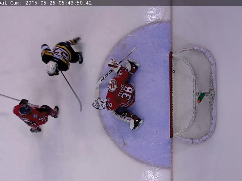 Two hockey players in front of goal keeper