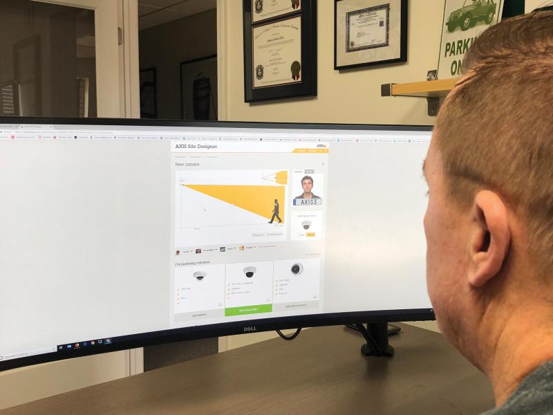 Man in front on screen showing Axis Site Designer