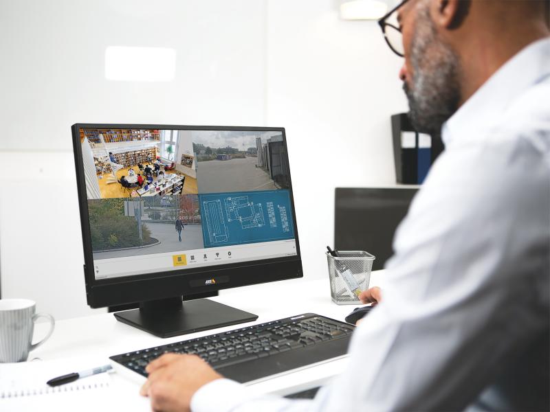 Man looking at computer screen showing surveillance footage