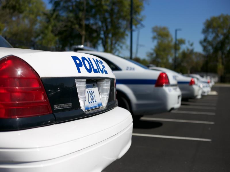 Back end of police cruisers in police department parking lot
