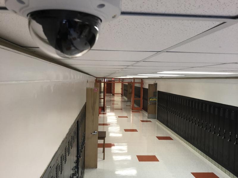 Camera mounted on ceiling in hallway of school