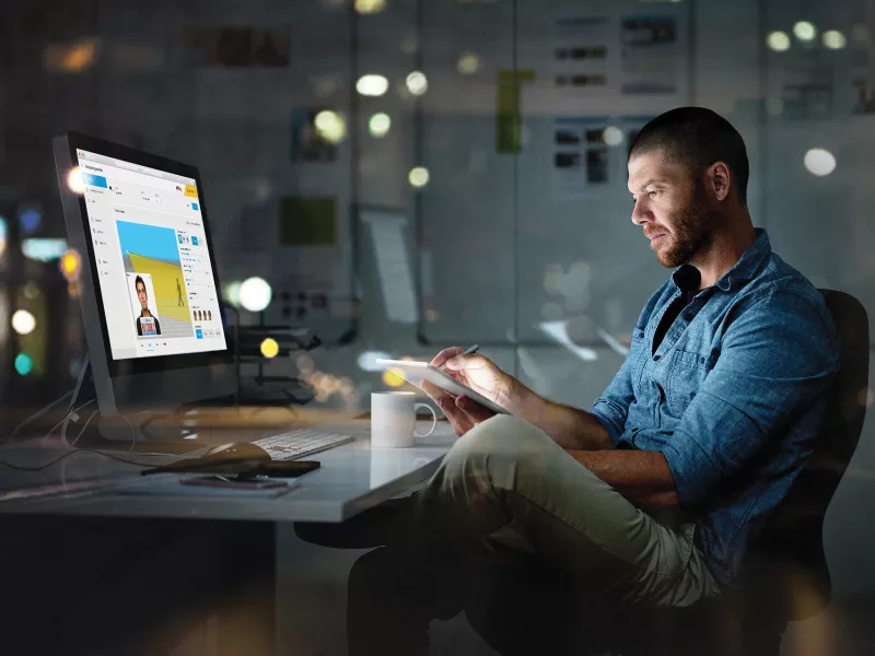 Business man working late in front of screen