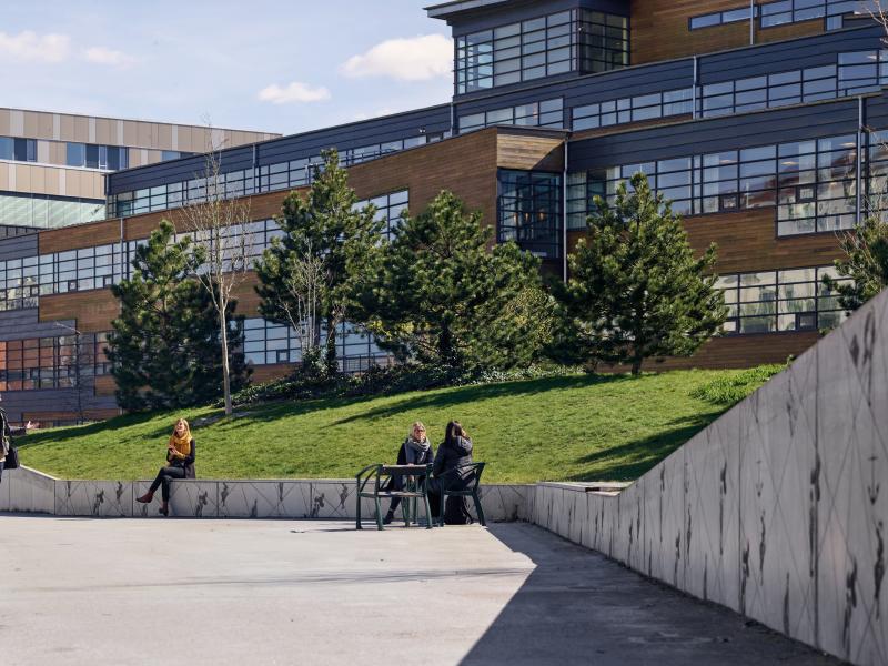 park with building, grass, sidewalk and people