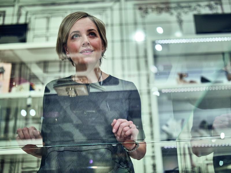 a woman standing behind a shop window