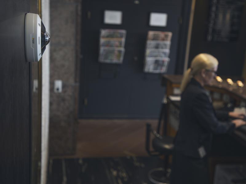 Hotel worker on computer, camera on wall