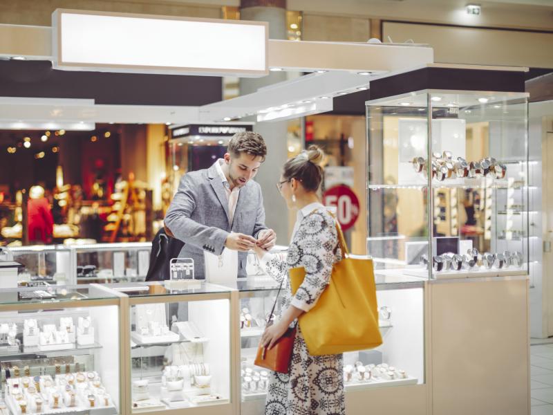 man helping female customer in a jewelry store