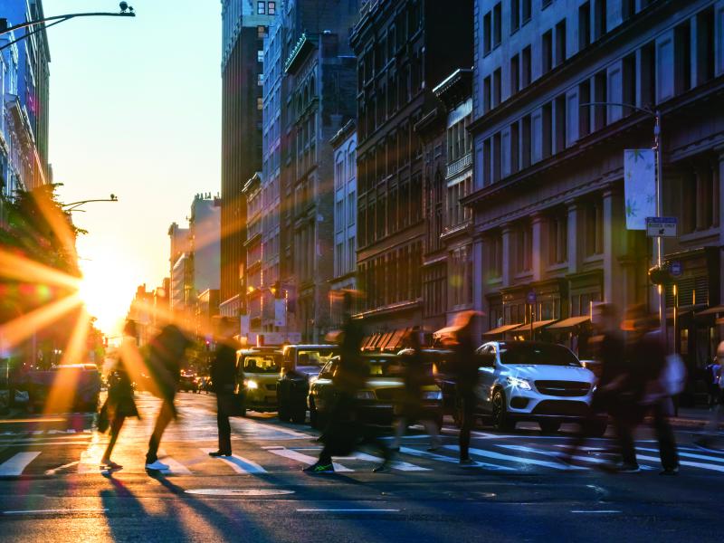 Crosswalk in the big city with people crossing and cars waiting