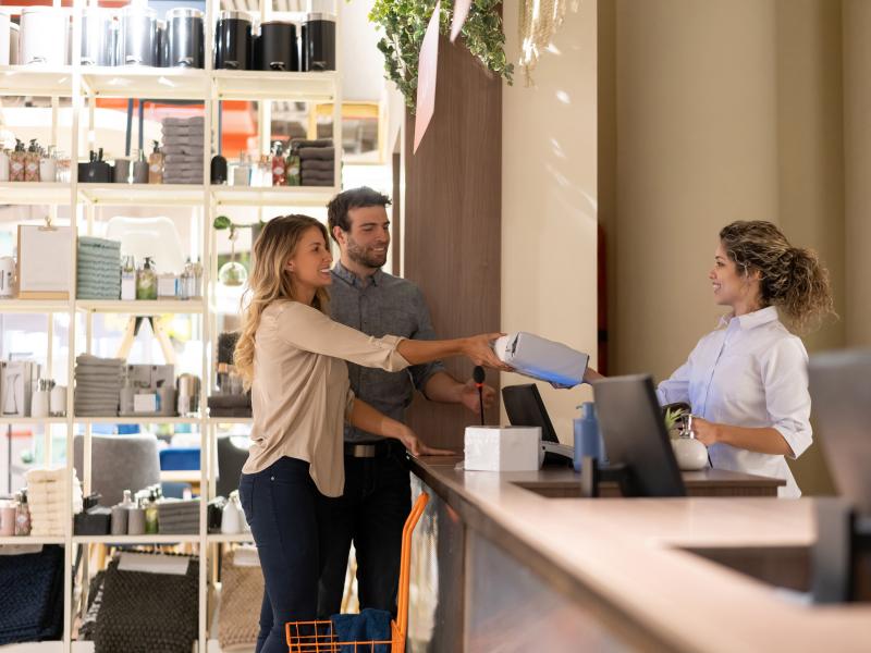 Couple purchasing from woman in cashier