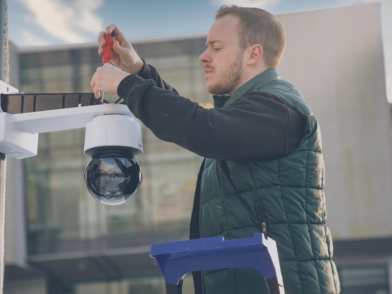 A man mounting a camera on the roof