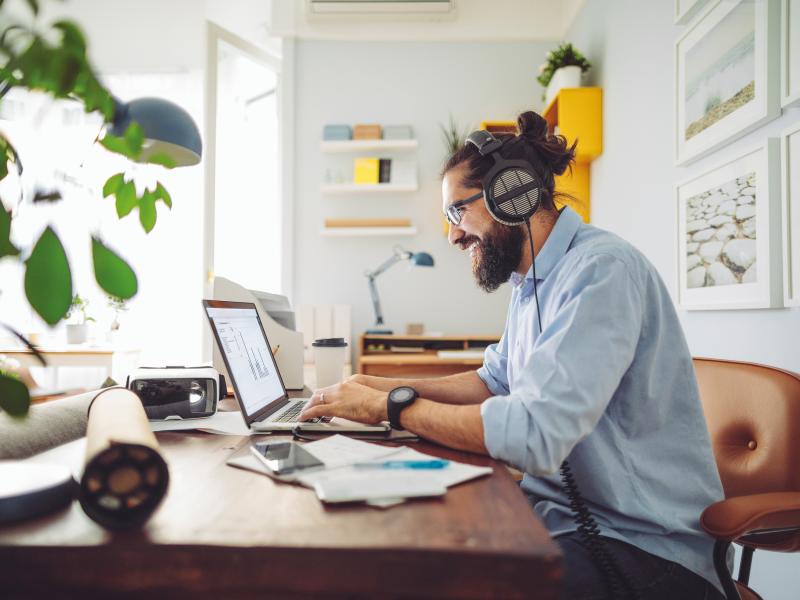 Man sitting in home office, smiling