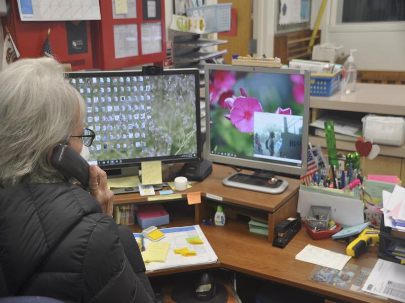 Staff member answer intercom at desk