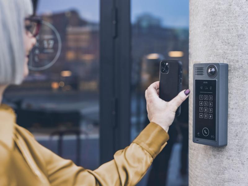 Woman scanning QR code with phone to open door