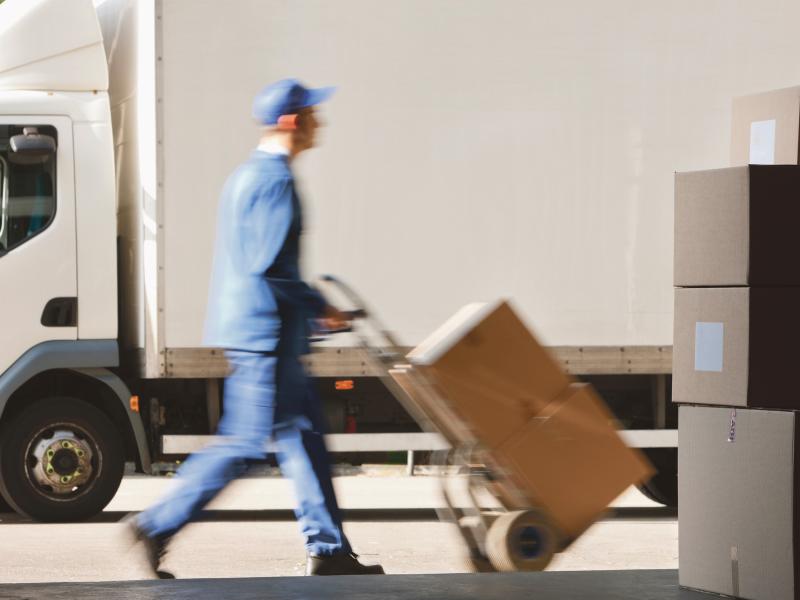 Delivery man with dolly and boxes