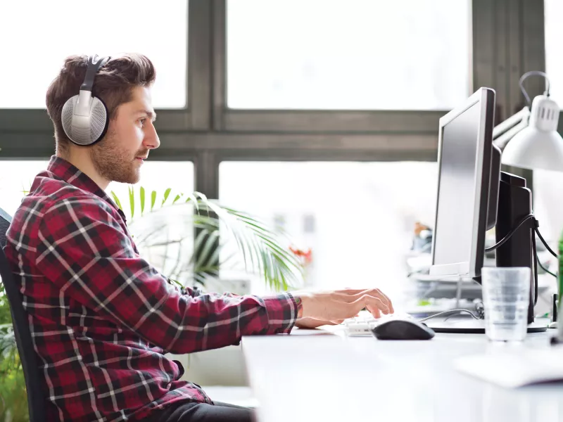 Man studying on the computer, watching a webinar