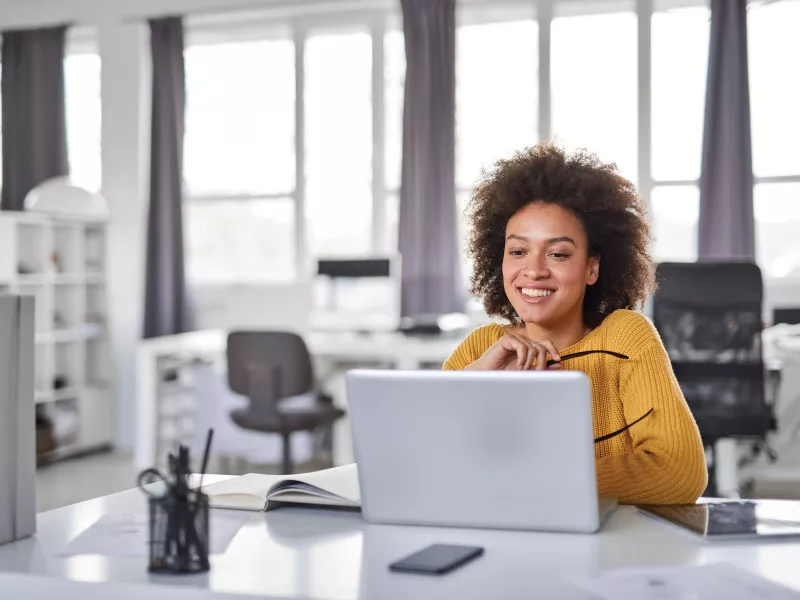 Woman sitting in office with a laptop