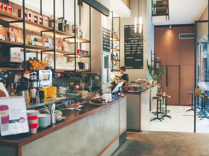 Serving area of a small cafe with dining area in the background