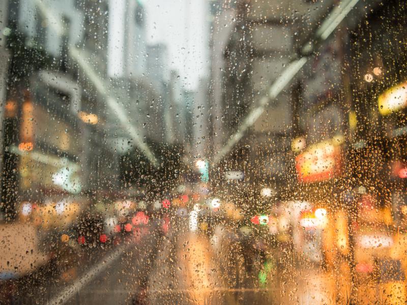 Picture of rain on a window in the middle of a city