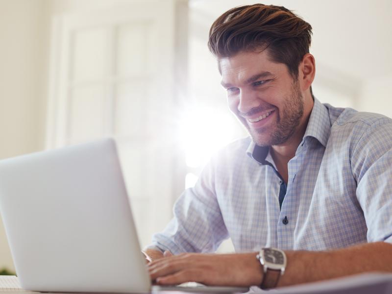 Smiling man with laptop. 