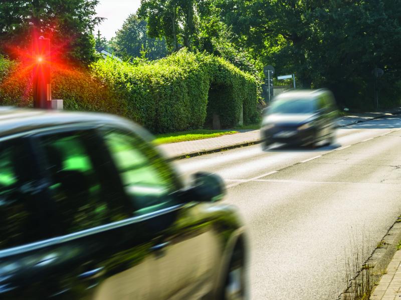 Cars passing on a road with a red light flashing