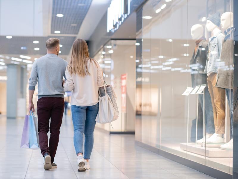 Man and woman walking in mall shopping.